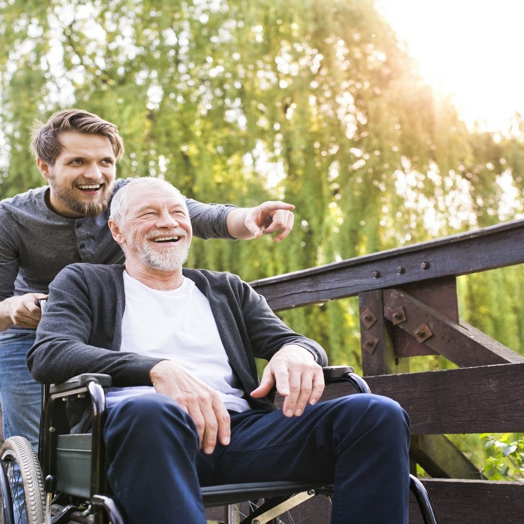 Carer Helping With Elderly Man In Wheelchair