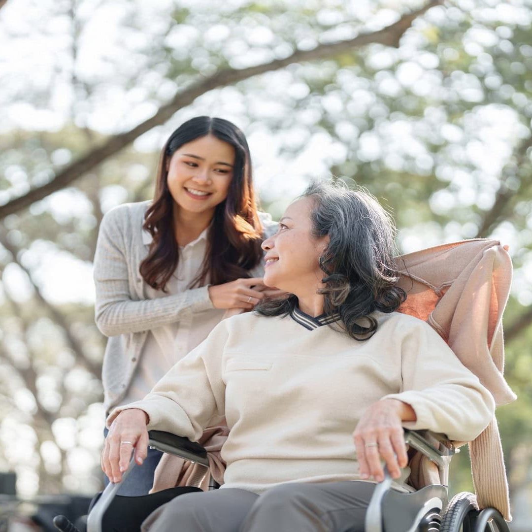 Young Caregiver Helping Senior Woman In Wheelchair